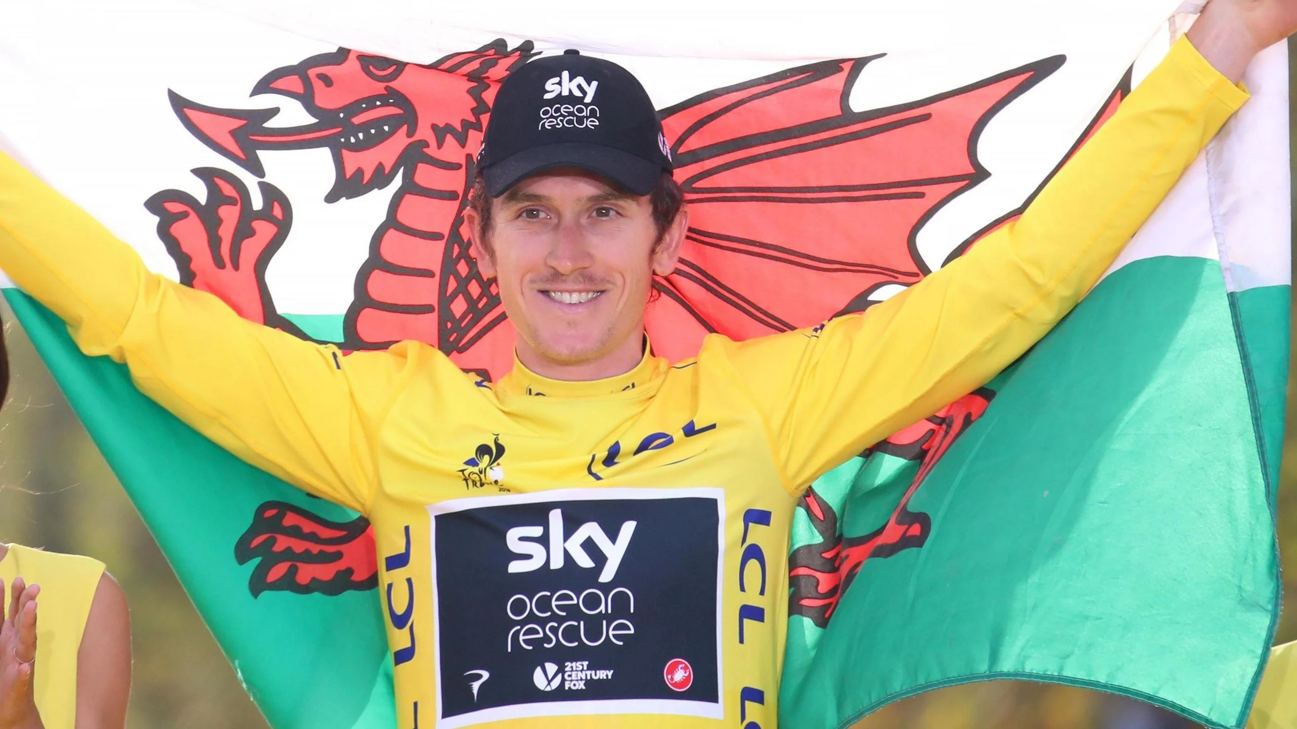 Geraint Thomas holds the Welsh flag after winning the 2018 Tour de France