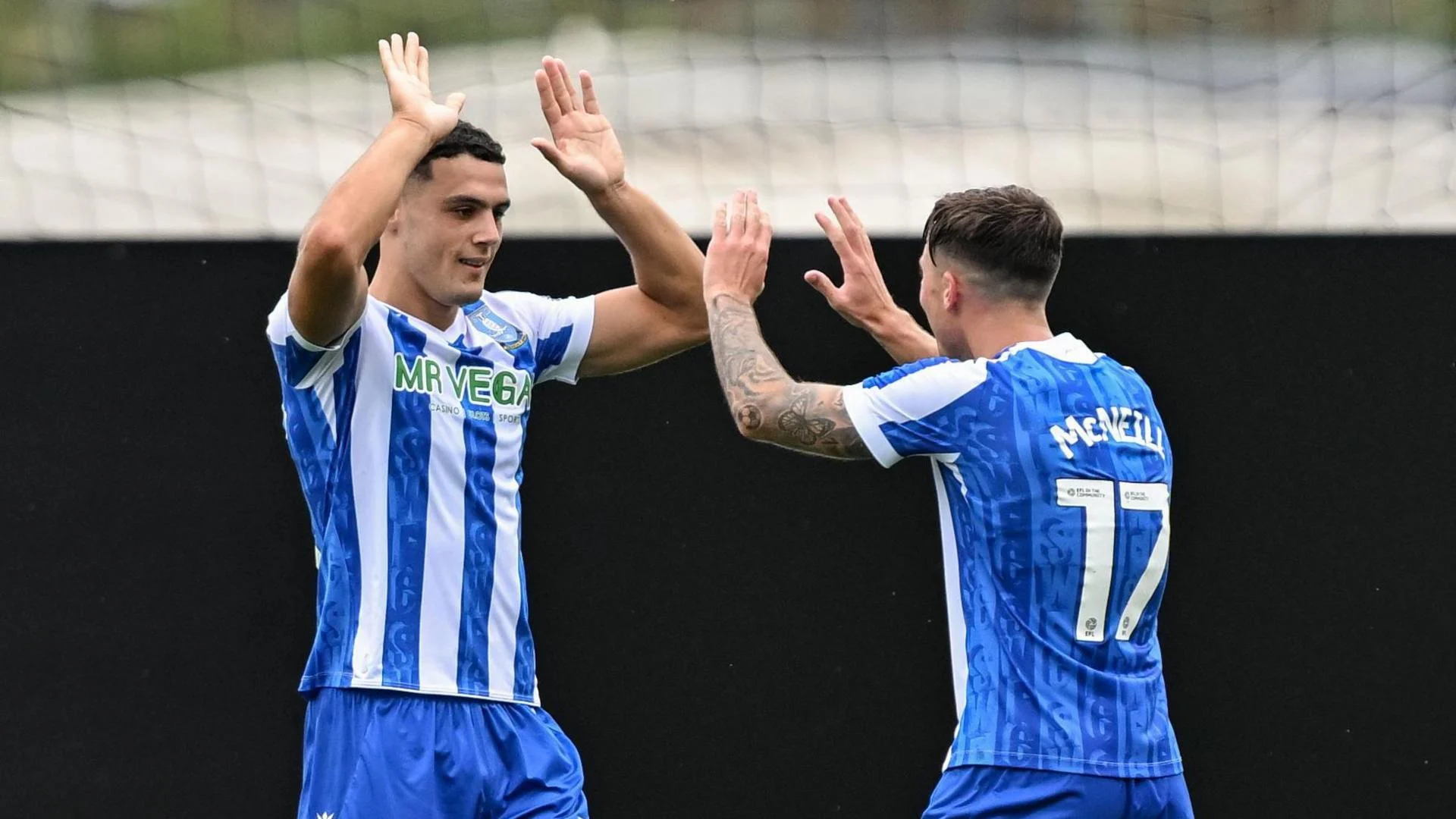 Bailey-Tye Cadamarteri celebrates with Sheffield Wednesday team-mate Charlie McNeill as both men raise their arms