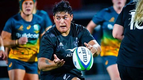 A female rugby player makes a quick pass