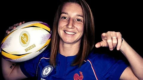 French scrum-half Pauline Bourdon Sansus points to the camera holding the women's rugby world cup 2025 ball in a portrait photo