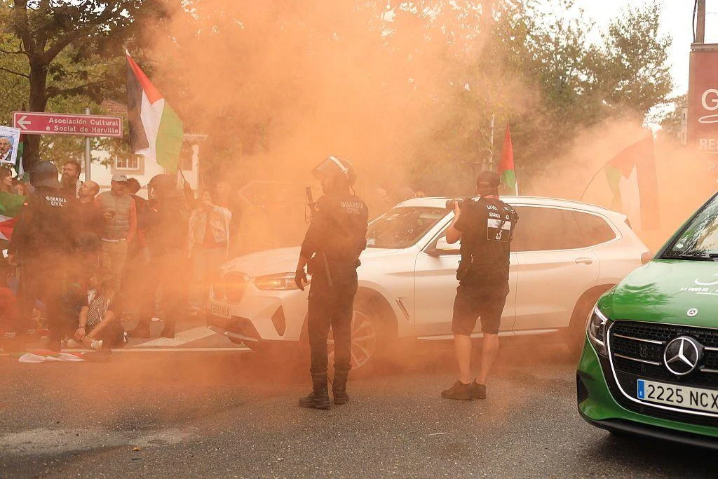 Protestors use flares as Police try to control them at the Vuelta a Espana