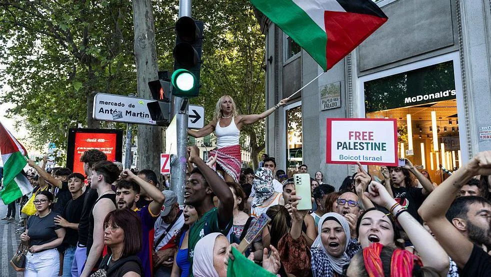 Pro-Palestinian protesters in a group with a flag and placard during the final Vuelta a Espana stage in Madrid